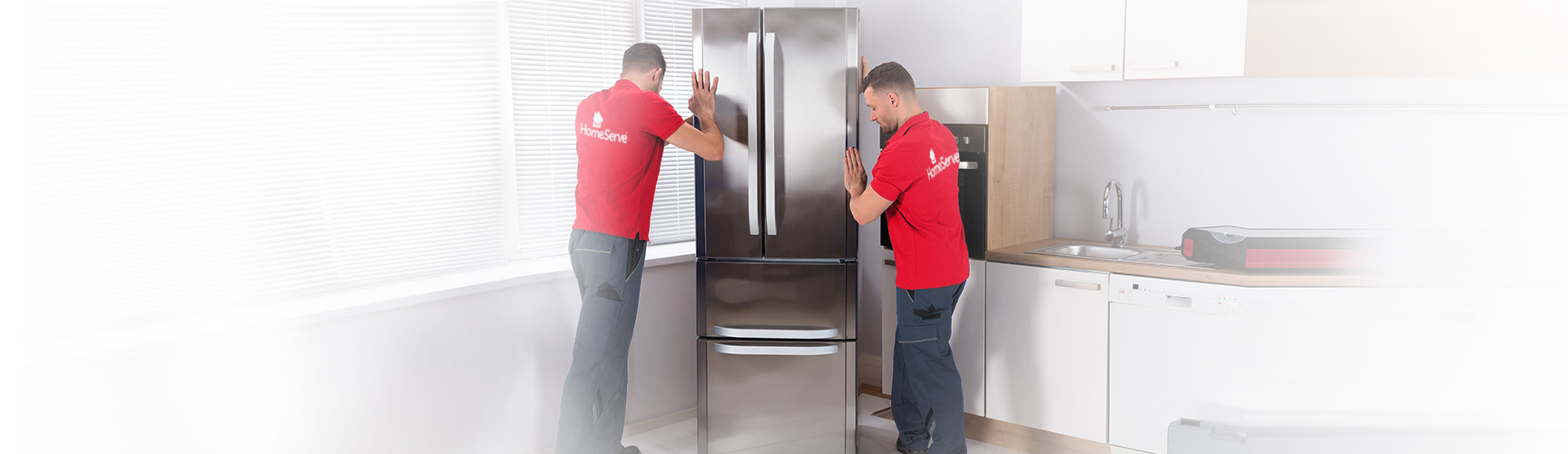 Dos técnicos de electrodomésticos de HomeServe reparando un frigorífico
