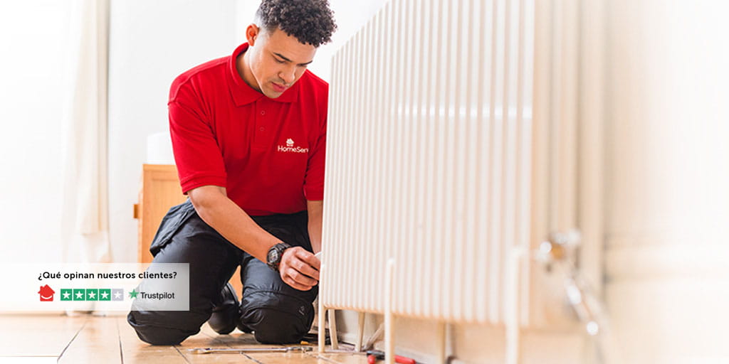 Fontanero de HomeServe cambiando un radiador en una habitación