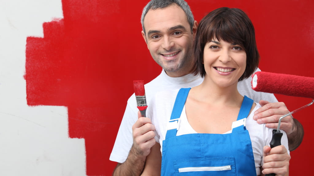 Pareja pintando una pared