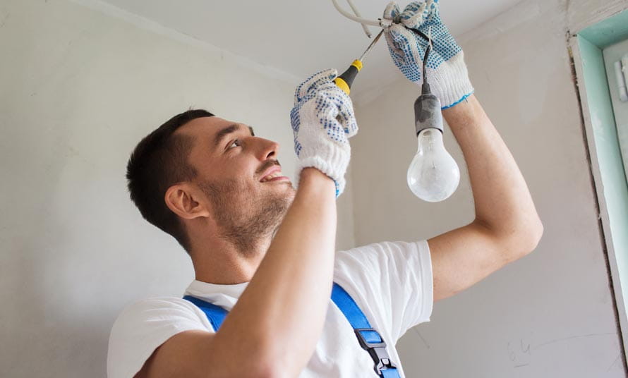 Un electricista de HomeServe realizando una reparación eléctrica